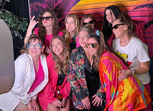 Loud colors were part of the Miami Vice vibe at Friday’s gala. Pausing for a group photo are, front from left: Jennifer Ryser, Taylor Woodman, Kylee Beins and Mandy Karr. Back from left: Megan Vetter, Jackie Johnson, Susie Moscrip, Celie Holliday and Heather Feik.