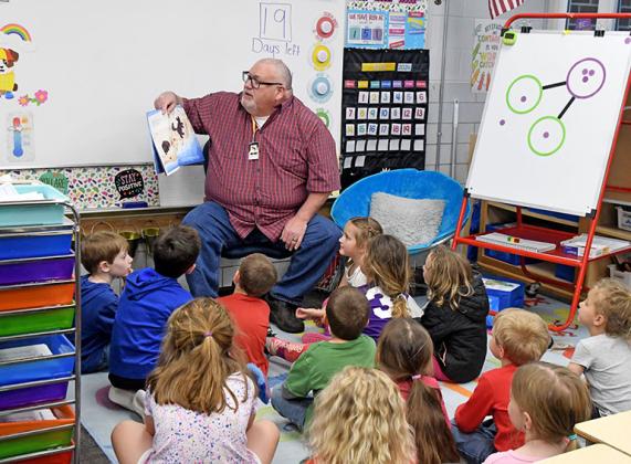 During his visit to Jayden Eby’s kindergarten class as a mystery reader, Pastor Bill Stearn read ‘Beloved’ by Jordan Feliz to the students with his granddaughter, Nora (center) sitting close to him.