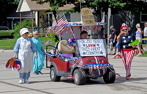 This entry in Sunday’s Booster Days Parade in Hampton won the prize for Best Theme with its America 250-themed costumes and decorations. From left above are Sharon Klute as U.S. Flag Creator Betsy Ross, Damaris Olsen as the Statue of Liberty, Jean Anne Schmidt as Miss USA and Loa Winter as Uncle Sam. 