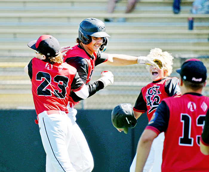 Sawyer Kiner (middle) celebrates with his teammates after launching a three-run homer to lift the Aurora Cooperative Post 42 Juniors team to a 5-1 win over Central City at the B-4 district tournament in York Monday. 