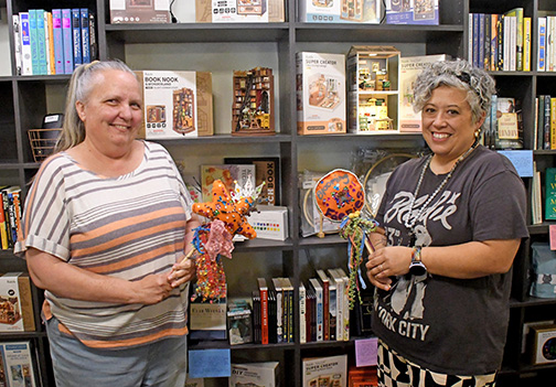 Espressions co-owners Lisa Montoya (left) and Maile Ilac Boeder show off some of the new books and other items that have been added to the newly renovated shop.
