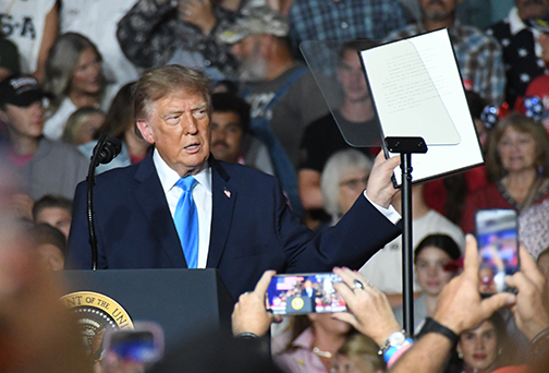 President Donald Trump holds up an executive order he is about to sign which allows federal excise tax free red dyed diesel to be used on the nation's highways through the end of the year. 