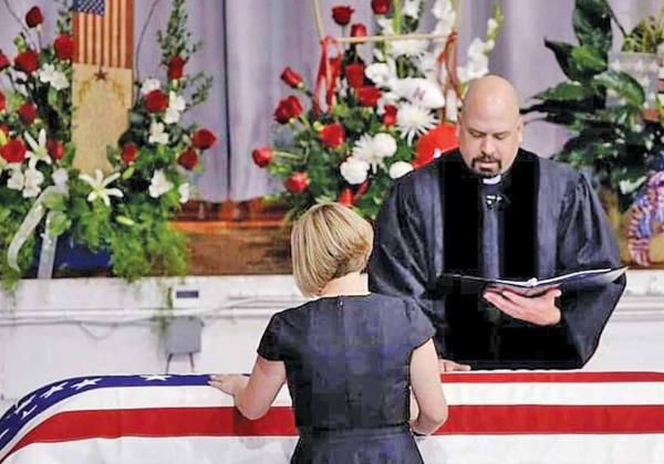 Dena Yllescas stands over her husband’s casket, Army Capt. Robert Yllescas, at his funeral in 2009. Yllescas died at the age of 31, after complications from a targeted attack by Afghan o auroranewsregister.com insurgents. This story is told in new film, “The Outpost.” Courtesy photo