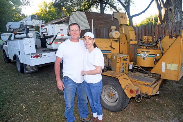 John and Jeannie Wilkinson stand beside the boom truck and wood chipper machine purchased recently to help launch their home-based JNJ Tree Service business.