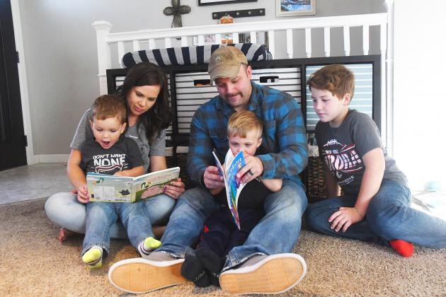 Becca Greenough (left) and son Alex Greenough read about farm animals while Tanner Greenough  and son Camden Greenough learn their colors. Big brother Tristan Greenough watches story time. 