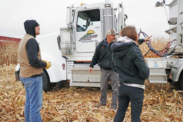 Grant Wilson (left), Cale Carlson and Laura Carlson made sure they had their trucks in the best spot to meet up with the grain carts Friday morning near McCool Junction.