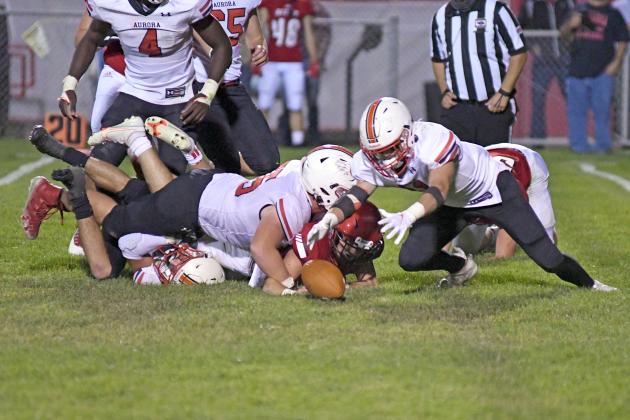 Aurora’s Brady Collingham (far right) falls on the second of his two fumble recoveries during the Huskies’ 21-7 win over McCook Friday night. Aurora rides a four-game win streak into a contest with Class B No. 1 Hastings. 