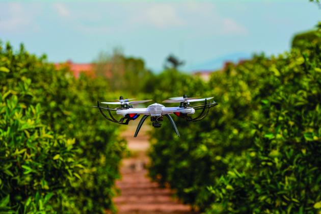 A drone flies above a field. 