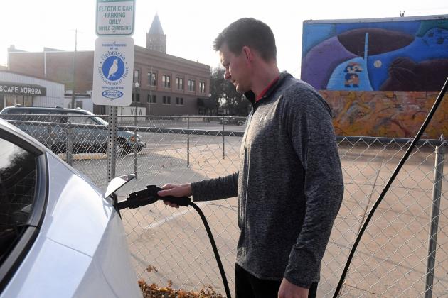 Chad Carlson plugs his electric vehicle into the newest charging station just north of the Youth Center.