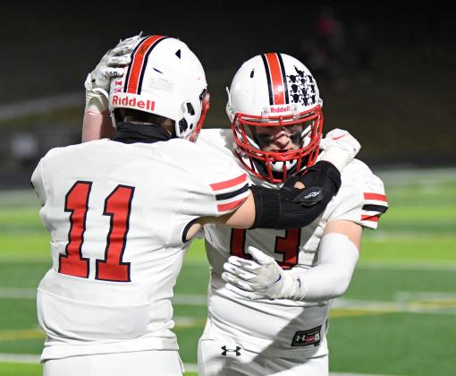 Brady Collingham (11) and Daniel Elge share a moment after their final football game as Huskies. 