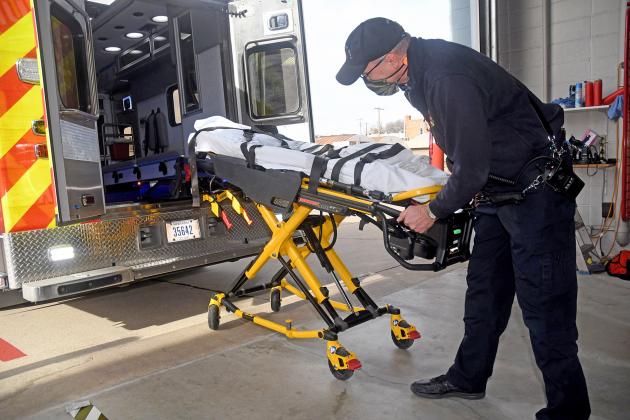 EMS Captain Brent Dethlefs demonstrates one of the new powerload cots, a piece of equipment which allows emergency personnel to load and unload patients using a rail system that significantly reduces the weight factor.