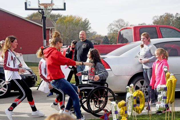 Trinidi Rice’s fellow cheerleaders rush to greet her upon her return home after almost three months recovering from a car accident.