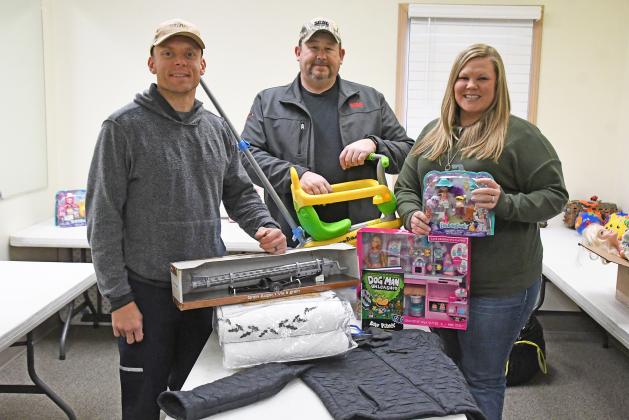 From left, Grant Hill, Scott Snider and Vicki Hill stand with some of the donated toys, clothing and other items for the free shop they will be hosting Saturday. 