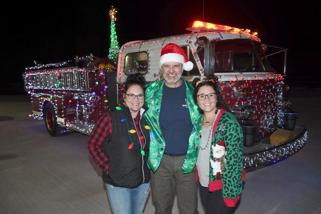 Perry Hosier spent two days placing some 5,000 Christmas lights on a 1965 fire truck, then paraded around Giltner Monday with his wife Carolyn and daughter Kaitlyn.