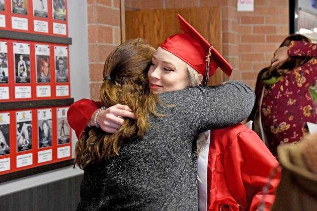 Aurora graduate Harley Jones shares an embrace with teacher Amy Hudiburgh. 