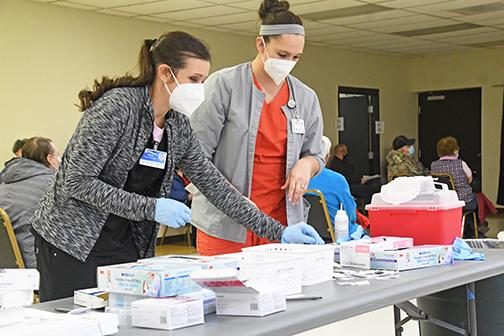 MCHI nurses Kellie Ommert, left, and Jamie Dibbern were joined by a large group of hospital personnel and volunteers to help distribute 360 COVID vaccines Thursday in Aurora.