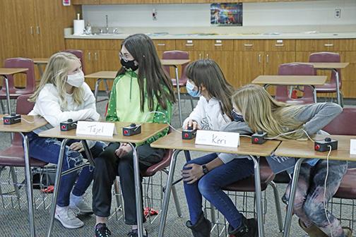 In a girls-against-boys team battle at practice, sixth graders Jillian Stromer (left), Tajel Lents, Keri Wagoner and Caitlin Salmon join together to go over a bonus question.