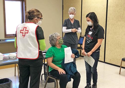 From left, Denese Hoegh, Marianne Meyer and Dr. Jen Harney surround one of 625 patients to receive the COVID vaccine during a 2-day clinic at the Bremer Center.