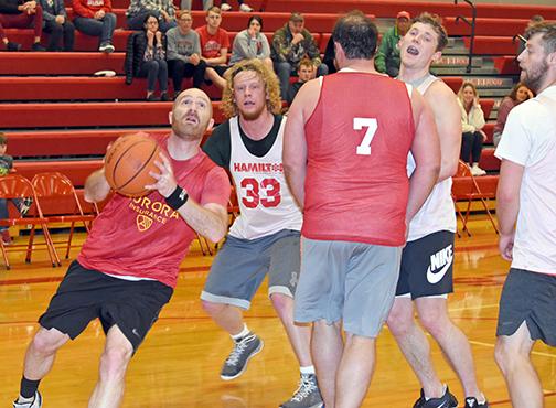 Brock Wyatt finds room to drive the lane during the Class of 2002’s 43-39 win over the Class of 2017 in the finals of the 32nd annual Bill Kropp and Curly Penner Aurora Alumni Basketball tournament Sunday. 