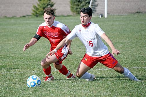 Aurora’s Eli Warnke battles for possession with a Crete player during Aurora’s 2-1 win over the Cardinals Thursday. 