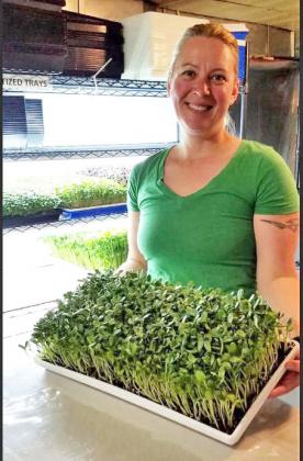 Sarah Martin holds up a tray of her microgreens. This Grand Island based business delivers fresh greens to both Phillips and Aurora.