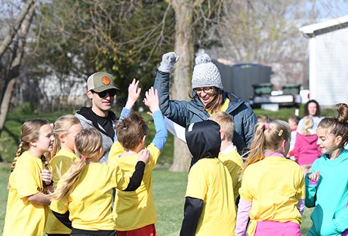 Coaches Tim Martin and Joanne Haidle break a team huddle with a cheer, all part of the action on a busy Saturday morning of youth soccer in Aurora.