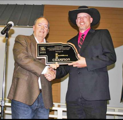 Nebraska Auctioneers Association vice president Scott Jarman (left) presents Mark Kliewer with the champion plaque after winning the bid calling competition.