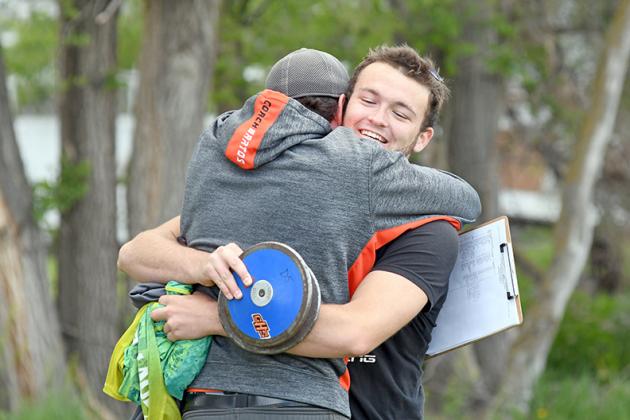 Giltner’s Jacob Smith shares an emphatic hug with Hornet throwing coach Chip Bartos after Smith qualified for the state track meet in the discus.