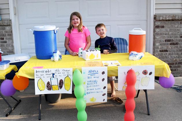 Eleanor (left) and Nolan Geiken man their lemonade stand as they work to gather donations.