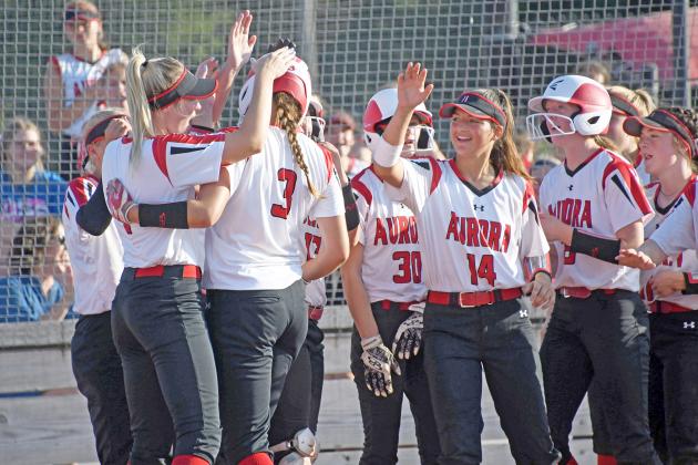 Rylee Olsen (3) is mobbed by her teammates at the plate following her solo home run in the first inning of Aurora’s 15-6 win over Lexington to open the 2021 season. Olsen had four hits in the victory. 