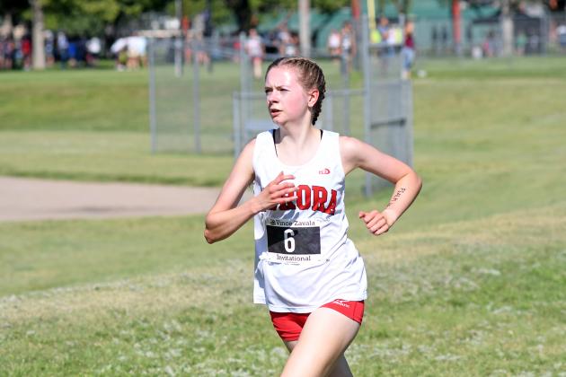 Aurora senior Elena Kuehner charges toward Tornado Hill for the first time during Friday’s Vince Zavala Invite. Kuehner finished third in the event with a time of 17:17. 