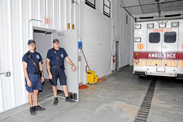 EMS Captain Brent Dethlefs, right, and crew member Chris Hyde stand in the doorway which connects the city’s new EMS living quarters to the ambulance bays.