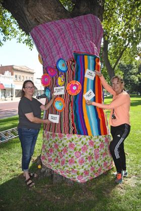 Cindy McClellan, left, and Jana Van Housen decorated a tree on the courthouse square as part of a Nebraska State Fair tree graffiti competition.