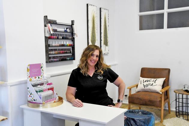 Christine Bellis sits in the area of Estheva Skin & Body, her new spa located in downtown Aurora,  dedicated to nails.