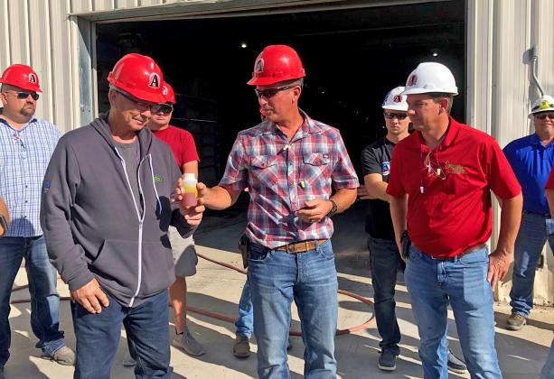 Participants on the ethanol plant tour pass around a sample of corn oil, one of several by-products produced at the Aurora facility.