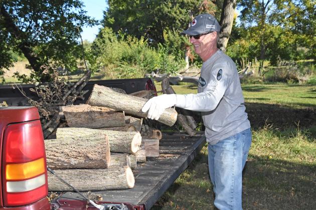 Paul Lackore loads cut lumber into a pickup as one of many Aurora United Methodist Church volunteers lending a helping hand by clearing the grounds at The Leadership Center.