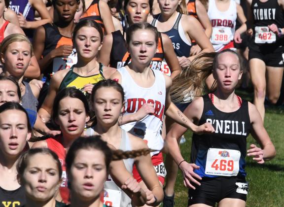 Aurora senior Elena Kuehner, pictured middle, heads for the first curve in a sea of runners vying for position at the start of the state cross country meet.