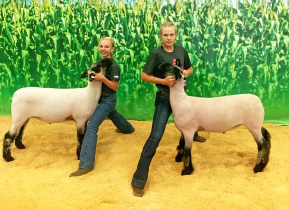Ava Myers (left) and Morgan Bonifas pose with their lambs from the Aksarben Lamb Challenge.