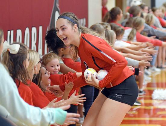 Rachel Hunter high fives Aurora's little diggers in attendance of Thursday's five-set thriller with Hastings. 