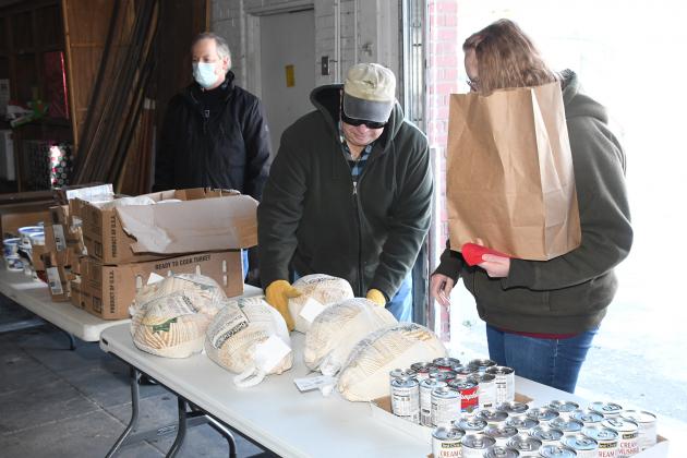 Craig Ratzlaff, left, and Darrell Schmidt helped load up food for families in need at Saturday’s  holiday distribution at the Hamilton County Food Pantry.