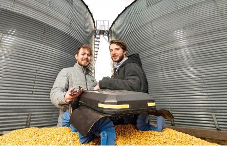 Ben Johnson, left, and Zane Zents display an updated version of The Grain Weevil, what the start-up company describes as “an ag robot doing the work that no farmer should.”