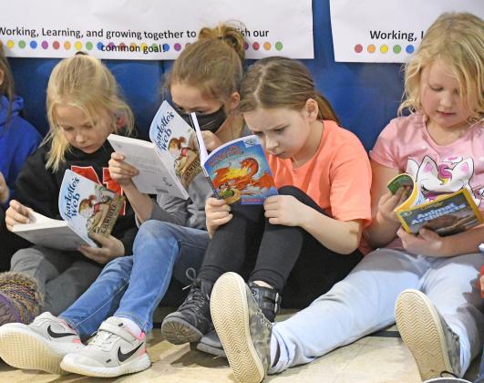 After picking out their choice of books, High Plains second graders, from left, Shayla Smith, Lacey Harris, Lyndsy Podliska and Kelsie Pike dive right in.