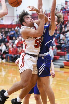 Aurora’s Carlos Collazo tries to go in for a layup during the second half against Seward but gets fouled. Despite the loss the Huskies have secured the top seed in this week’s Central Conference Tournament.