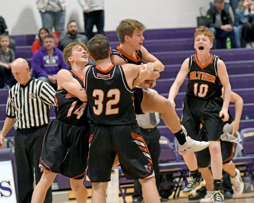 Giltner’s Cooper Reeson (center) is mobbed by his teammates after making a last-second three to defeat Hampton 41-40 Friday night. 