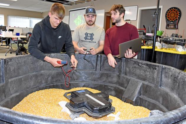 Caden Carlson, left, is gaining experience in the tech sector through an internship with the Grain Weevil Corporation. Pictured here observing the Grain Weevil in action at the Aurora Technology Center are Ben Johnson and Zane Zents.