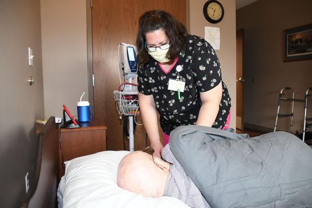 Barb Morris, an LPN and MDS coordinator at Westfield Quality Care in Aurora, takes the blood pressure of Wayne Hilder, a resident at the long-term care facility on 1st Street.