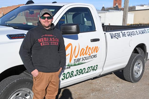 Jordan Watson stands by his new “mobile office,” a pickup featuring his new Watson Turf Solutions logo. The Aurora graduate has worked for other lawn care companies for 17 years and decided last fall to start his own business.