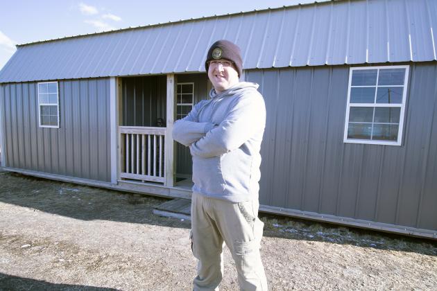 Marcus Lewis stands outside of ‘The Shed,’ his tiny home, on March 9. He and his fiancee have lived in the home for almost two years. 