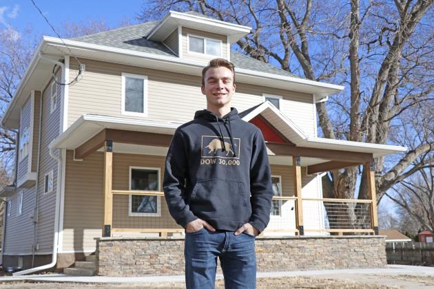 Aurora High School senior Jeremy Hunter stands in front of one of his many wholesale houses,  sold to and renovated by Alan Nunnenkamp.