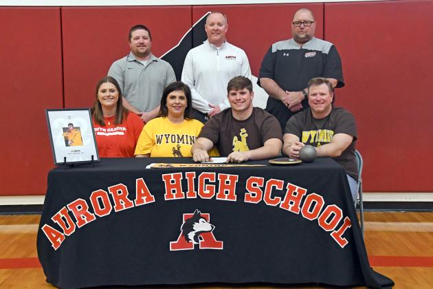 Aurora’s Gage Griffith signed with Wyoming to participate in track and field alongside his parents, Jeff and Melissa, sister Riley and Aurora coaches from left Bodie Moeller, Gordon Wilson and Scott Jones. 